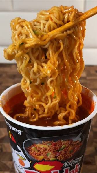 Buldak cup noodles lifted with chopsticks